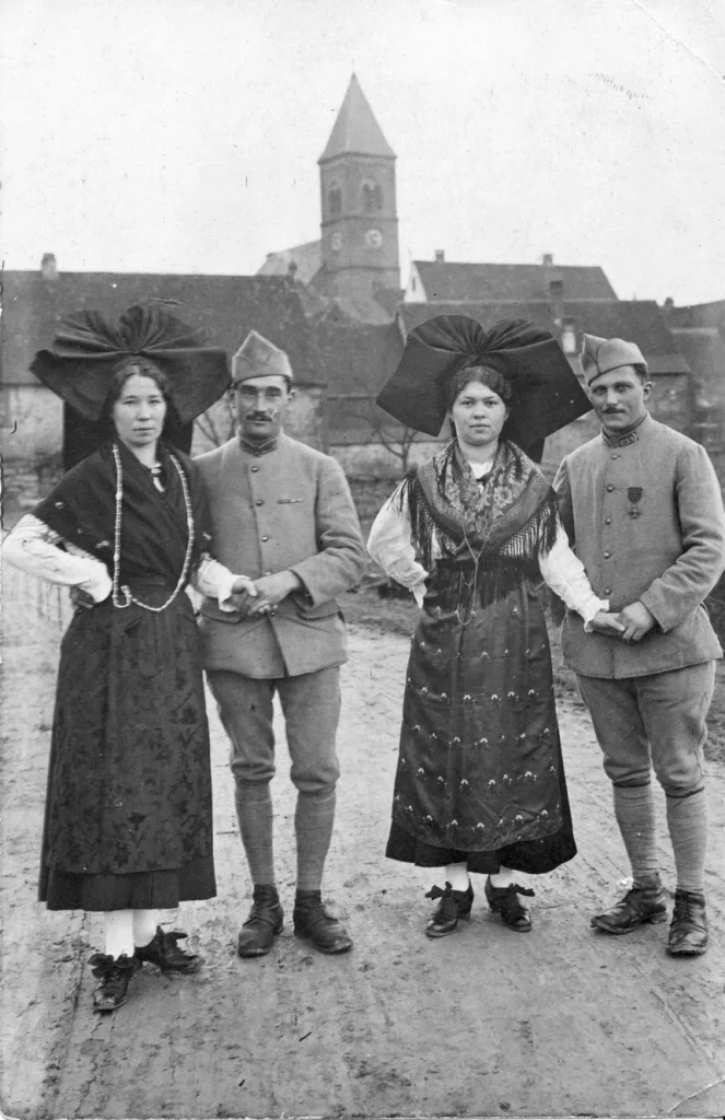 Deux Alsaciennes en habits traditionnels posent avec deux soldats français