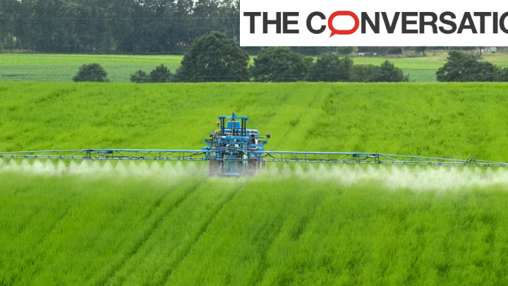 Photo d'un engin agricole en plein épandage de pesticides dans un champs
