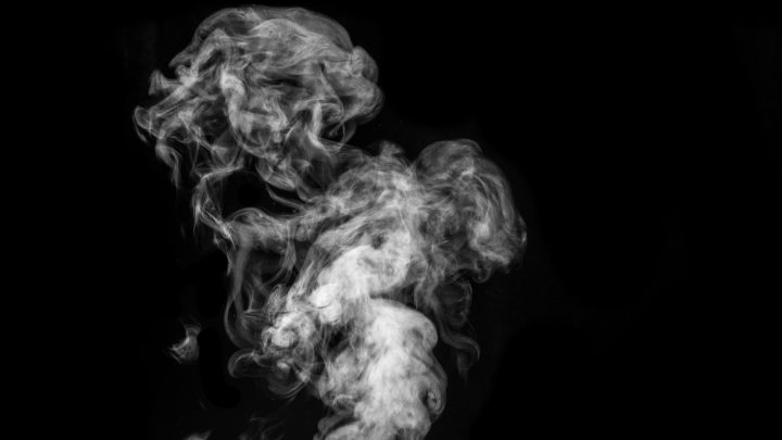 Fumée s'élevant sur un fond noir