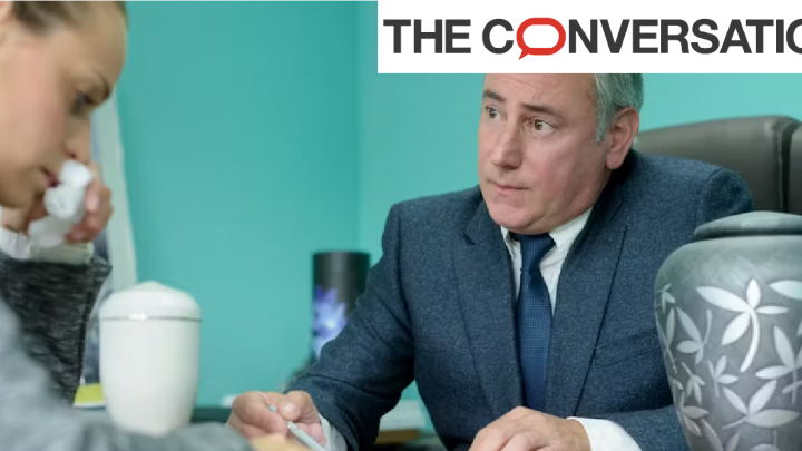 Employé de pompe funèbre accueillant une cliente à son bureau