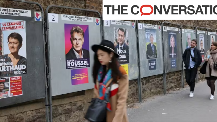 Femme passant devant des affiches pour les élections présidentielles