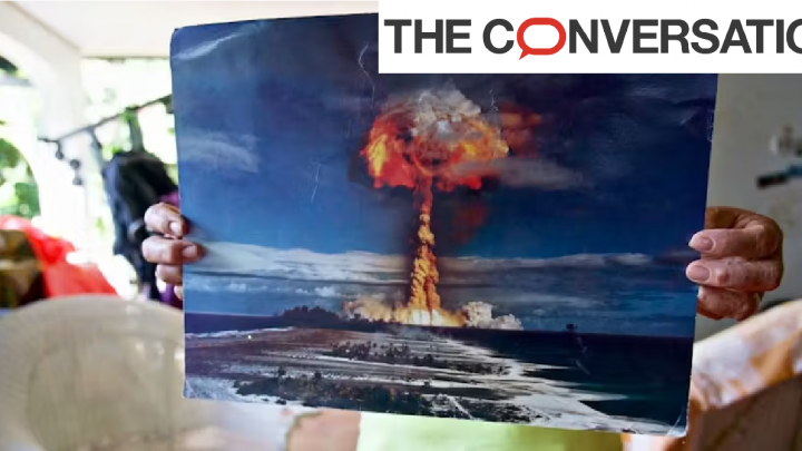 Un habitant des îles Gambier montre une photo du premier essai nucléaire conduit par la France en juillet 1966 en Polynésie française