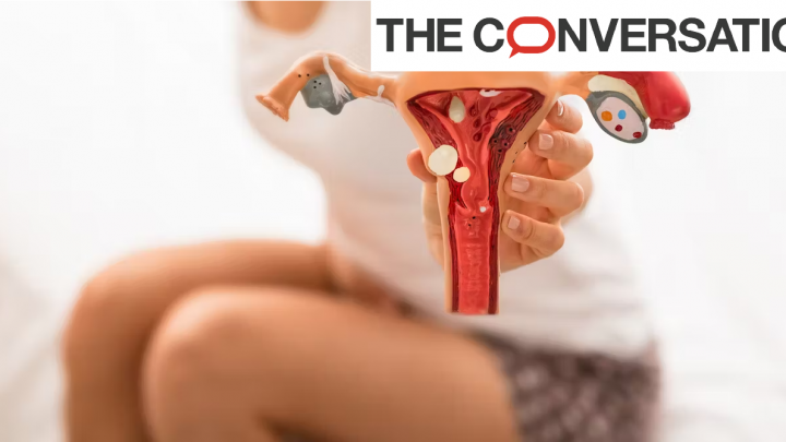 Photo d'une femme prostrée montrant un modèle d'utérus