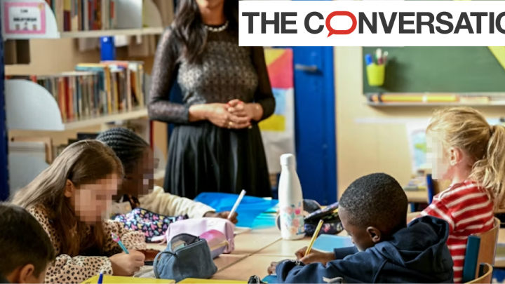 Classe avec des élèves autour d'une table, supervisés par une professeure