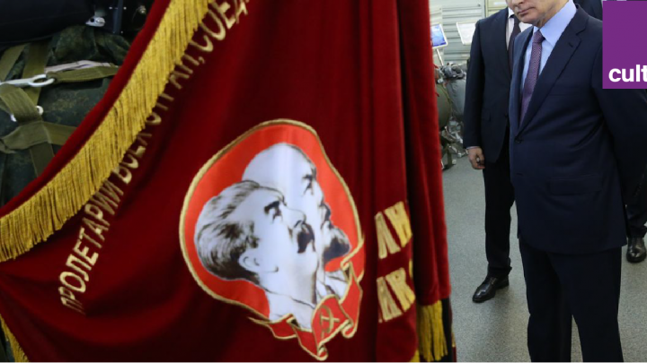 Vladimir Poutine devant un drapeau avec Lénine et Staline représentés dessus
